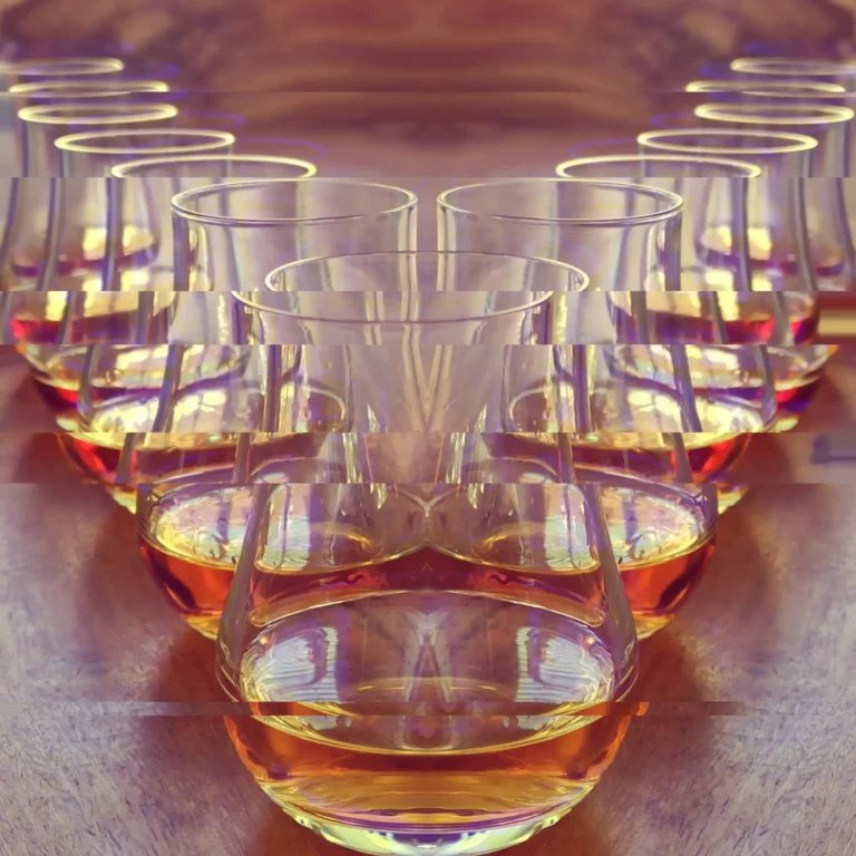 Close-up of a hand cradling a rounded snifter glass of aged French brandy, warming the spirit to release its aromatic bouquet